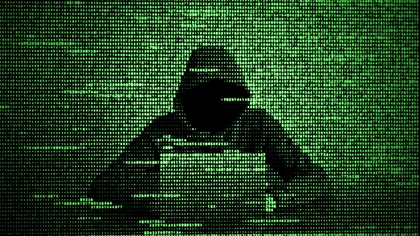 représente un hacker devant un ordinateur portable sur fond vert montrant des lignes de code